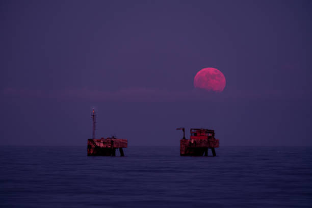 Image of the full moon of June. Called Strawberry Moon. Scenic view of the moon's exit on platforms in the Mediterranean Sea, Costa del Sol, Malaga. Full June Moon, also called Strawberry Moon. red full moon stock pictures, royalty-free photos & images