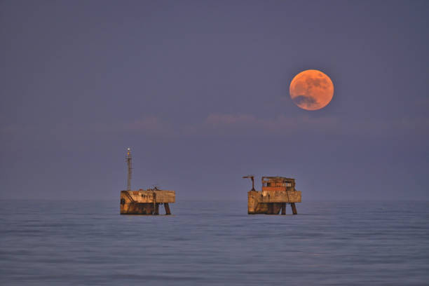 Image of the full moon of June. Scenic view of the moon's exit on platforms in the Mediterranean Sea, Costa del Sol, Malaga. Full June Moon, also called Strawberry Moon. red full moon stock pictures, royalty-free photos & images