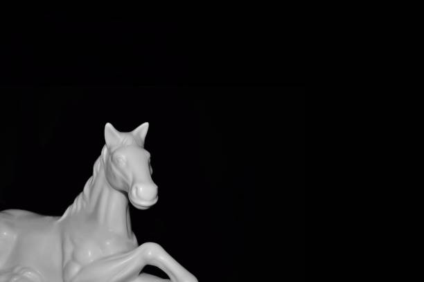 istock White Horse sculture black background 1325578433