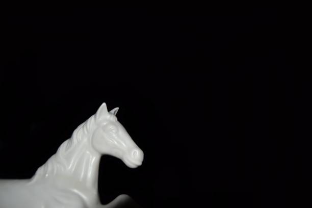 istock White Horse sculture black background 1325578450