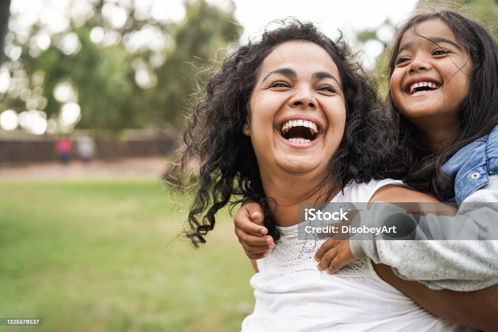 Mãe indiana feliz se divertindo com sua filha ao ar livre - Família e conceito de amor - Foco no rosto da mãe - Foto de stock de Família royalty-free