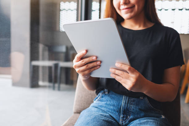 istock a beautiful young asian woman holding and using digital tablet in cafe 1325579507