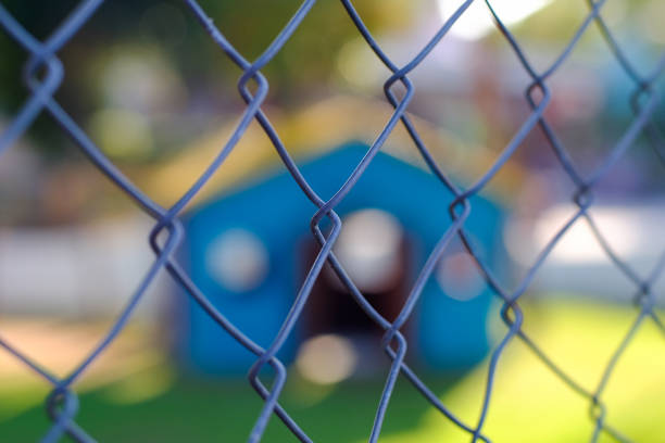 clôture en treillis métallique avec fond flou. - green fence chainlink fence wall photos et images de collection