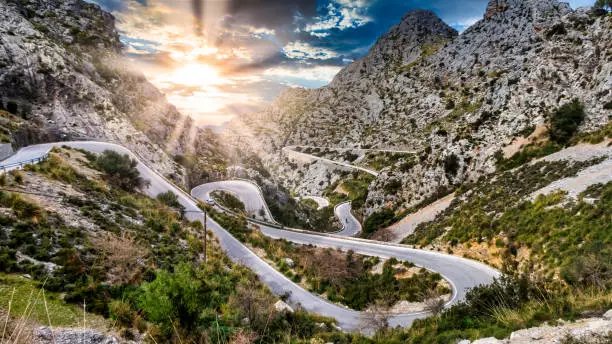 Photo of Serpentine Road with sunset and some cyclist at majorca, mallorca island