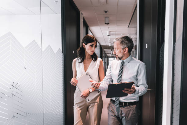 istock Confident business partners walking down in office building and talking 1325583667