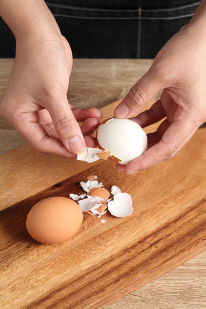 istock Chef peeling boiled egg on wooden cutting board in kitchen 1325585398