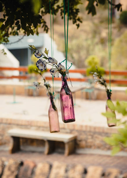 istock Colored bottles are decorated with flowers and hung from tree branches 1325587384