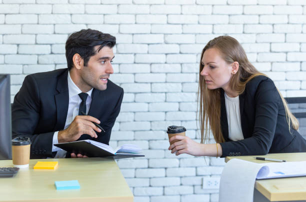 istock A young European woman drinking coffee while discussing work with her colleagues 1325588743