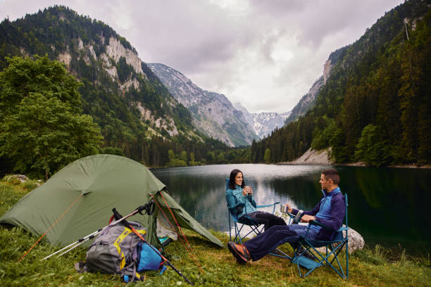 An adventurous young couple at their campsite and drinking coffee An adventurous young couple at their campsite and drinking coffee durmitor national park photos stock pictures, royalty-free photos & images