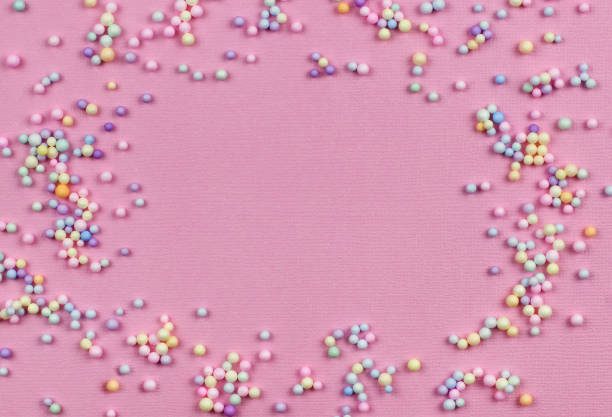 istock Small colorful pastel balls in a frame on pink paper 1325589622