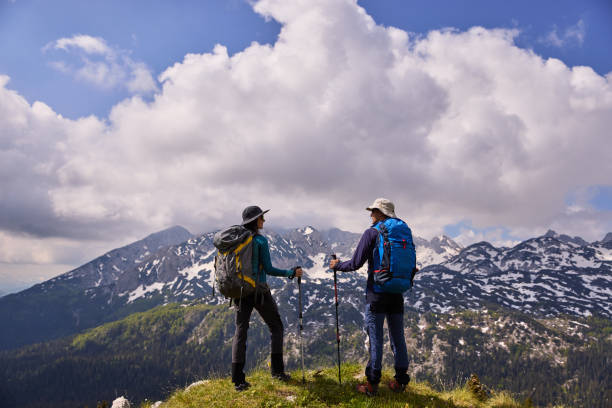 istock Hikers with backpacks relaxing and enjoying the view 1325589655