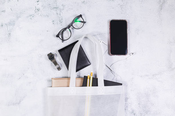 istock White women's leather bag with eyeglasses book and smart watch, phone, earphone, notepad. 1325590075