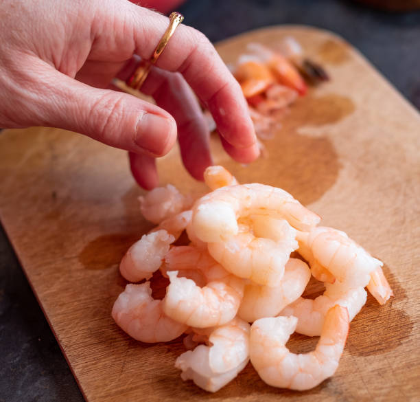 istock Removing the tails from king prawns 1325590900