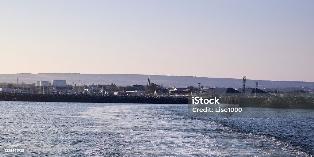 As you leave on the boat, look out over the city. Water point of view, this town is Rimouski, Quebec, Canada. Located near the St. Lawrence River, it is a port city. We can see the wharf as well as buildings and companies. September 2008. Architecture Stock Photo