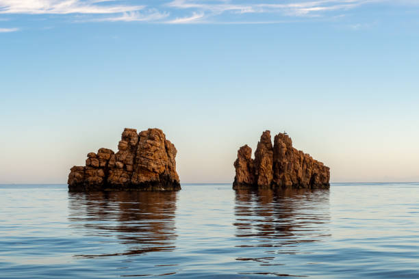 rocas nes portes con una cruz en la parte superior, al norte de la isla de paros que sobresale de la calma perfectamente plana del mar mediterráneo. - nes fotografías e imágenes de stock
