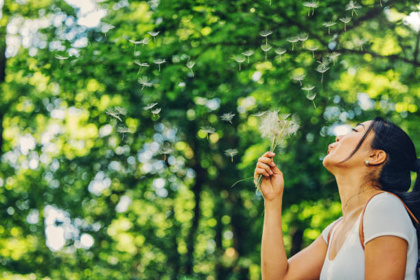 istock Woman Blowing the Dandelion 1325598554