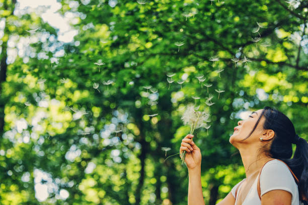 istock Woman Blowing the Dandelion 1325598559