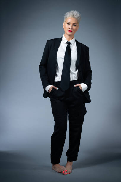 Young Citizen in Black Suit and Tie A young citizen of Los Angeles poses in studio in a black suit and tie and red lips. woman necktie stock pictures, royalty-free photos & images
