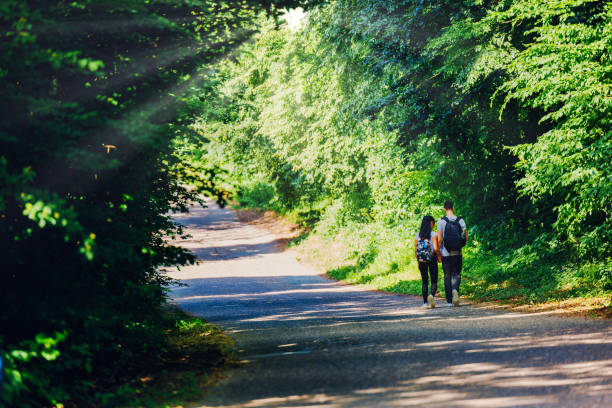 Couple seen at distant walking back home after a long summer day trail