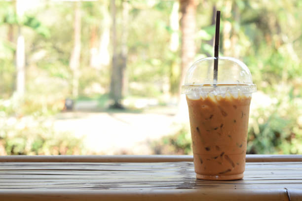 istock Iced Thai Milk Tea in transparent plastic glass on bamboo litter 1325603327