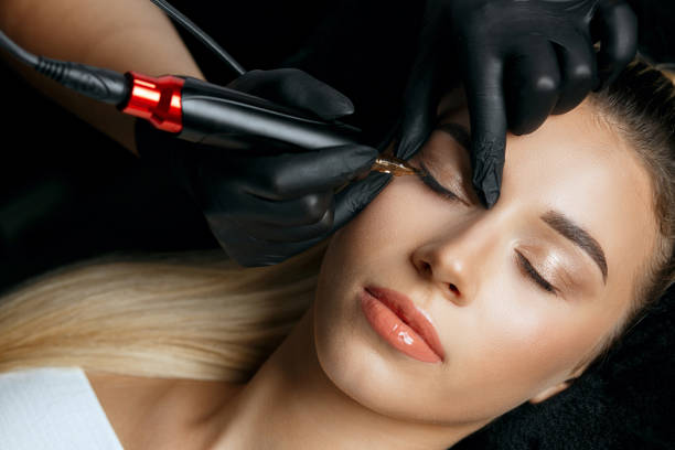 Woman in having permanent makeup Closeup shot of a woman in black gloves making permanent eyelid makeup to a young woman client in beautician salon. Top view eyeliner stock pictures, royalty-free photos & images