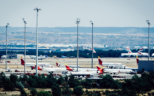 Madrid Bajaras, June 26, 2021: Long zoom view of airplanes on tarmac and iconic roof of Bajaras Airport in Madrid, Spain