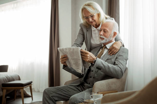 pareja de ancianos amoroso leyendo periódico por la mañana - hotel newspaper coffee reading fotografías e imágenes de stock