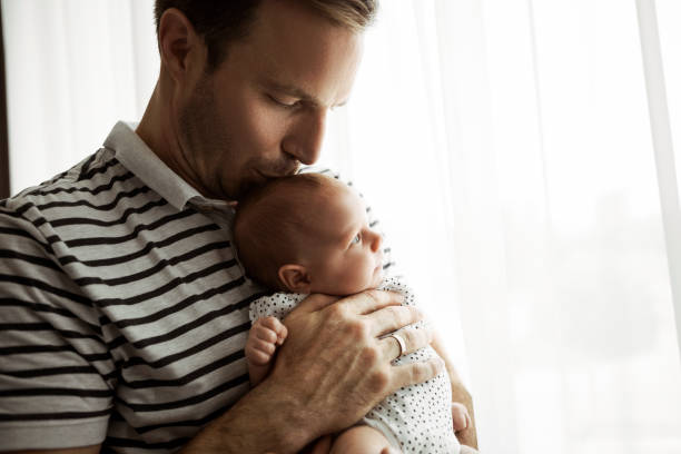 istock Father with his newborn child cuddling near window 1325621114