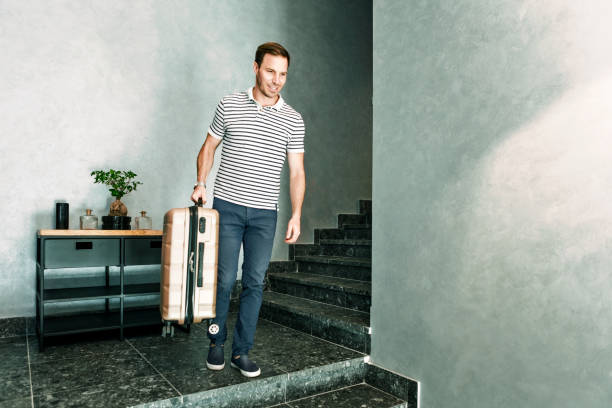 istock Happy young man with travel bag inside hotel checking out 1325621249