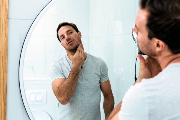 odbicie człowieka z brodą patrząc na lustro i wzruszającą twarz - men shaving human face bathroom zdjęcia i obrazy z banku zdjęć