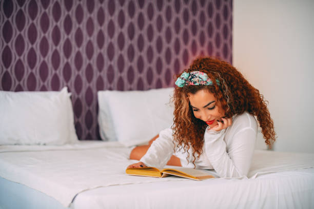 istock Beautiful Woman Reading a Book in Her Bed 1325625085