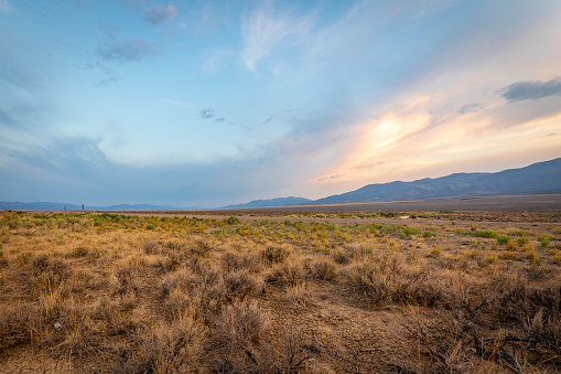 Late-day sunlight colors massive cloud formations over the desert near Ely, Nevada.