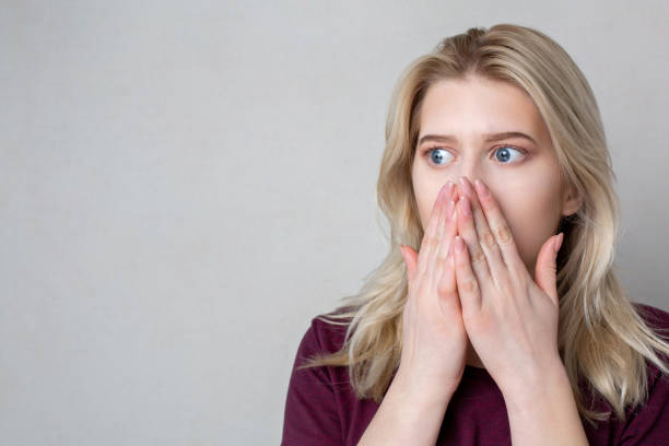 istock Closeup shot of scared young woman standing over a grey wall. Empty space 1325637221