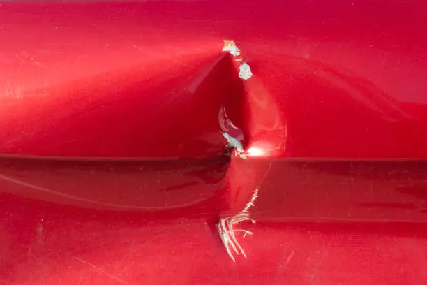 Photo of A dent in the car. The spoiled surface of the car.