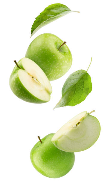 istock falling green apples with slices isolated on a white background 1325647697