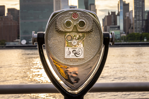 A coin operated viewfinder in Queens overlooks the East River with Manhattan on the other side