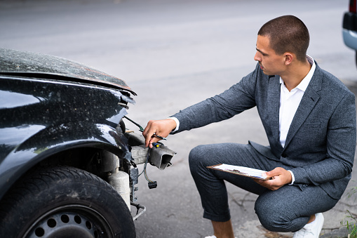 Insurance Agent Examining Car After Accident Or Crash