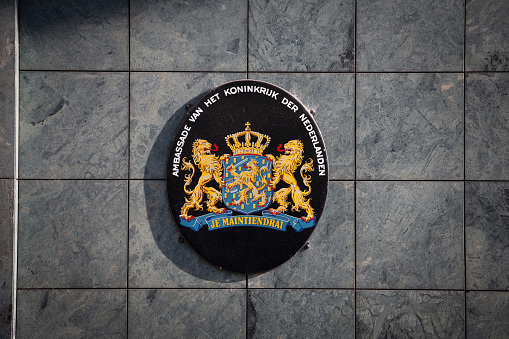 Amsterdam, Netherlands: civic coat of arms of Amsterdam- red shield and a black pale with three silver Saint Andrew's Crosses - shield of Amsterdam on a brick wall.