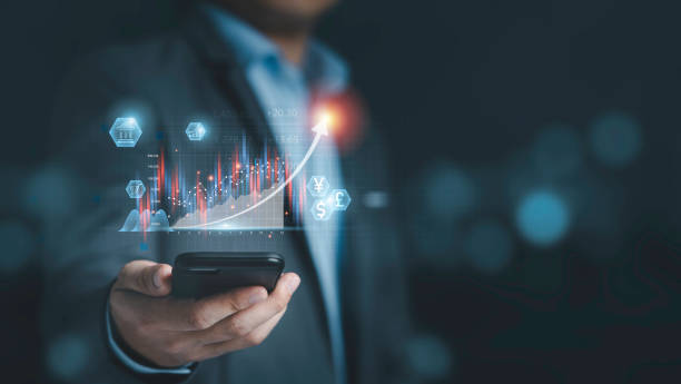 istock Businessman holding smartphone with  virtual technical graph and chart for analysis stock market, technology investment and value investment concept. 1325662163