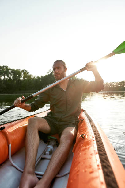 istock Adventurous young man looking away while kayaking in a lake on a summer day 1325662325