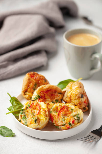 istock Egg muffins ( bites) and spinach leaves  in a plate on a gray background 1325663208