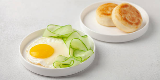 istock Eggs, cucumber in a plate and curd pancakes on the table.  Healthy breakfast 1325663217
