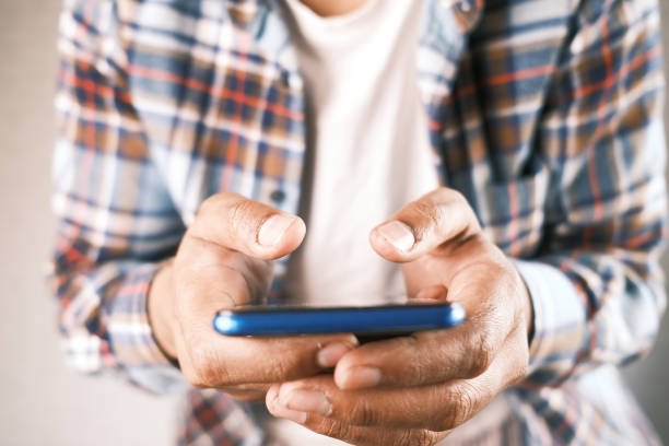 istock Close up of young man hand using smart phone. 1325664693