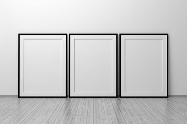 istock Mockup template of three A4 frames with thin black frame border standing next to wall on wooden floor 1325666587