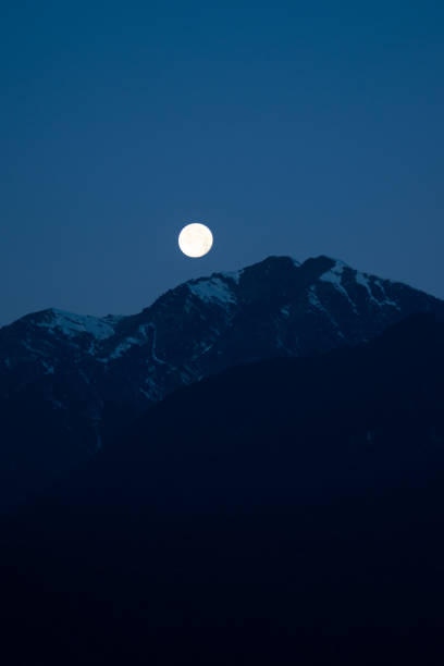the moon over the austrian mountains in winter