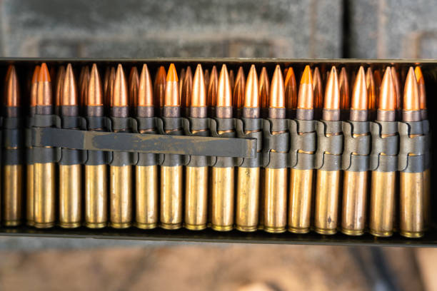 Row of heavy machine gun bullets. Row of heavy machine gun bullets which is packed in the ammunition cartridges. Firearm and weapon object photo. Selective focus. ammunition stock pictures, royalty-free photos & images