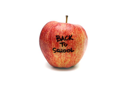 Closeup of a red apple with back to school written on it.