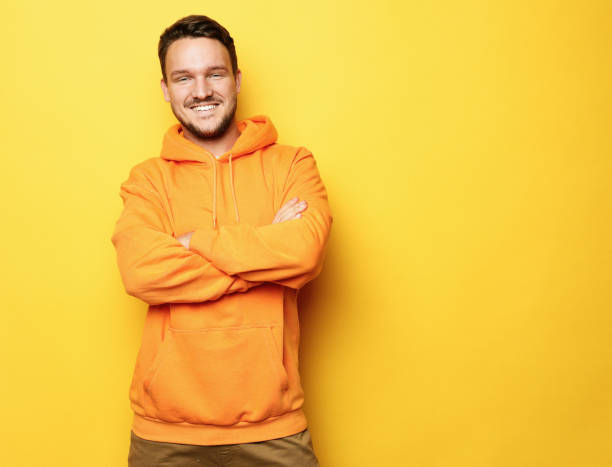 istock Smiling man standing against yellow background 1325673616