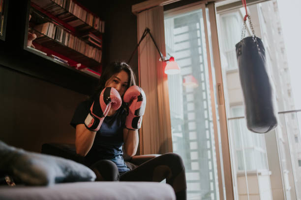 istock Ready for Boxing class at home, Active woman act how to guard before start boxing class - stock photo 1325674421