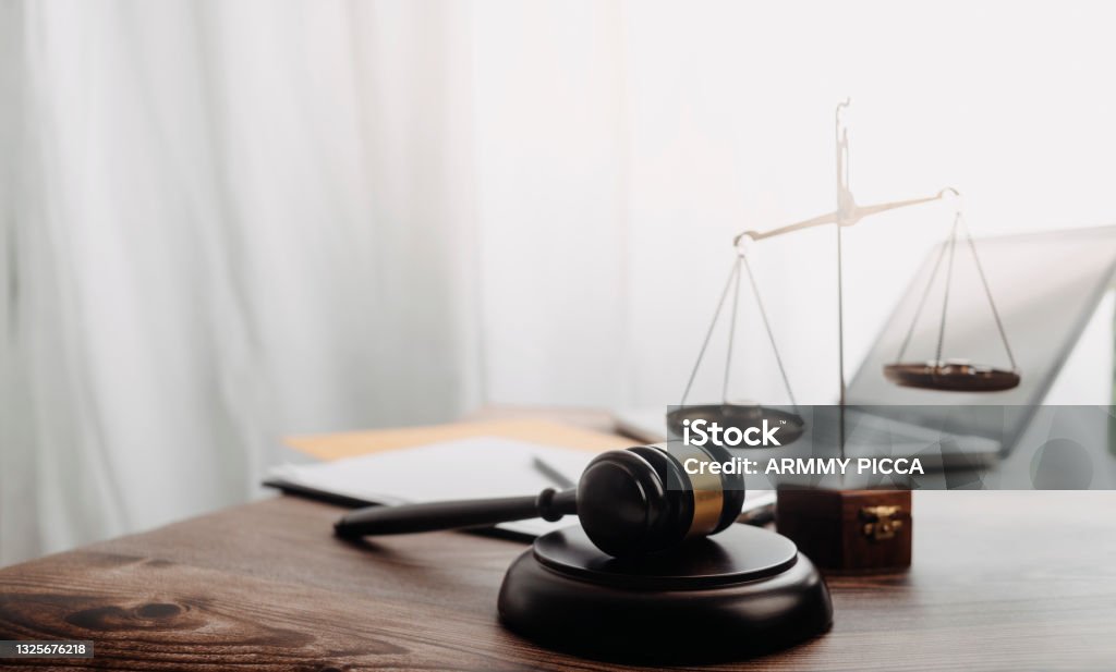 Business and lawyers discussing contract papers with brass scale on desk in office. Law, legal services, advice, justice and law concept picture with film grain effect Law Stock Photo